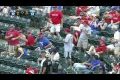Fan grabs a foul ball without having to interrupt his cell conversation